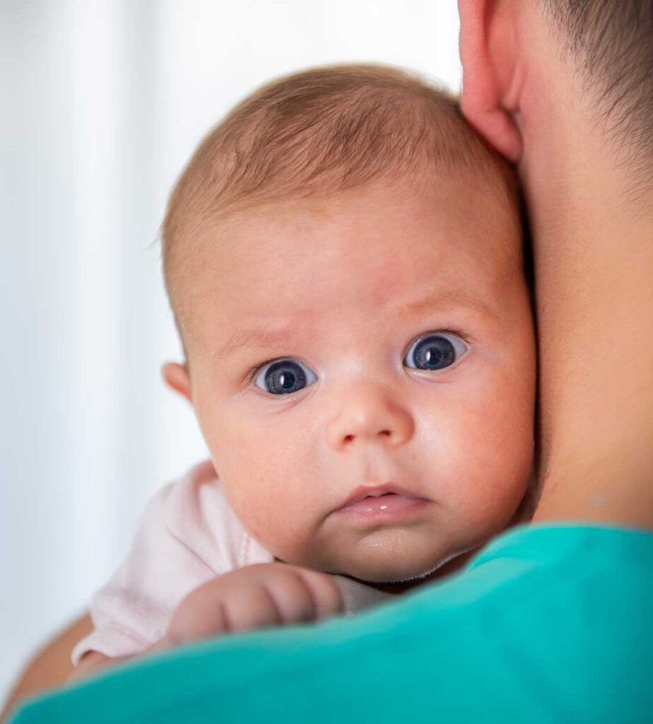 neonato in braccio ad un dottore che deve effettuare il sondaggio delle vie lacrimali